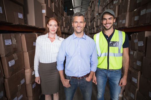 Warehouse team smiling at camera in a large warehouse