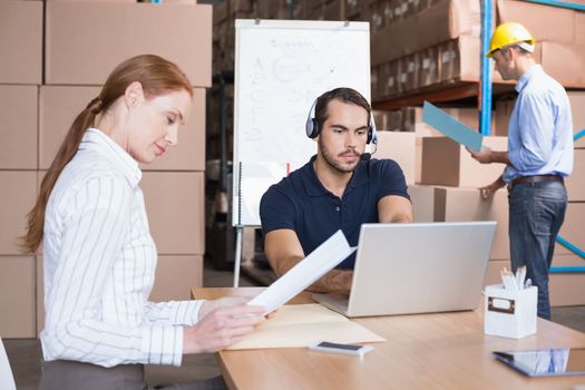 Warehouse team working together on shipment in a large warehouse