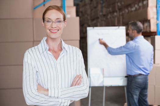 Warehouse manager smiling at camera in a large warehouse