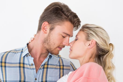 Close up of romantic young couple about to kiss over white background