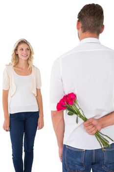 Man hiding bouquet of roses from young woman over white background