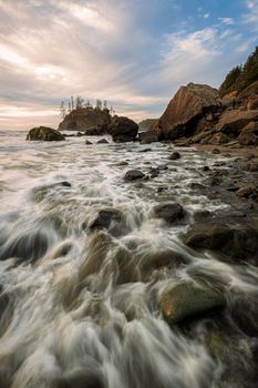 Sunset at a rocky beach with vivid warm colors and beautiful skies.