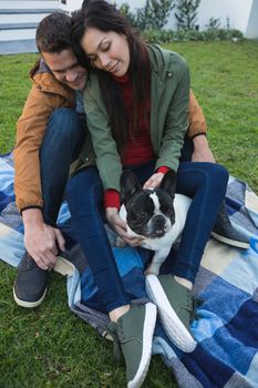 Couple playing with their dog in the park