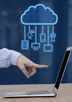 Digital composite of Hand pointing at laptop with cloud icon and hanging connection devices