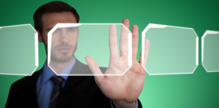 Close up of businessman touching palm on invisible interface against abstract green background