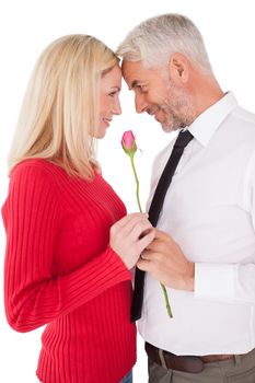 Romantic mature couple holding rose over white background