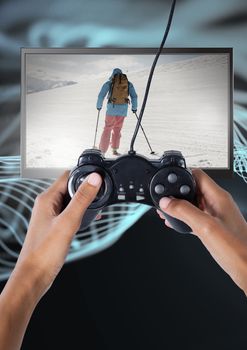 Digital composite of Hands holding gaming controller  with skiing person on television