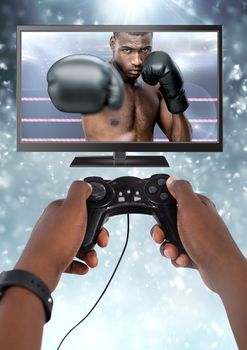 Digital composite of Hands holding gaming controller  with boxer fighter on television