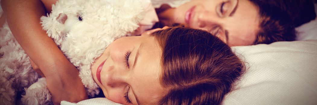 High angle view of family sleeping on bed at home