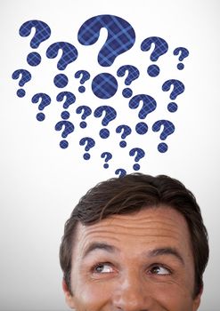 Digital composite of Man thinking with blue thatched question marks
