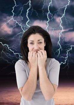 Digital composite of Lightning strikes and scared afraid woman biting nails