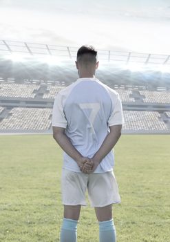 Digital composite of Soccer player standing in stadium on pitch