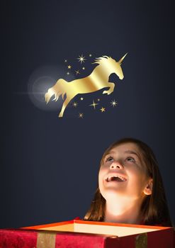 Digital composite of Golden unicorn and stars over magic light box and little girl