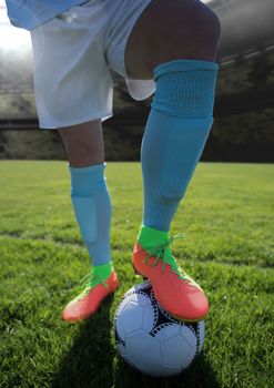 Digital composite of Soccer players on grass with football in stadium