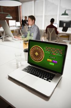 Online Roulette Game  against laptop on table with business people in background