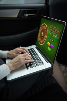 Online Roulette Game  against woman using laptop while sitting in car