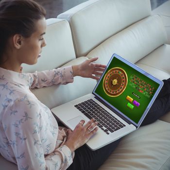 Online Roulette Game  against businesswoman using laptop while resting on sofa