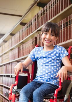 Digital composite of Disabled School girl in education library in wheelchair