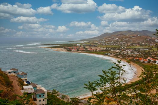 A curved beach with tropical condoes and resorts