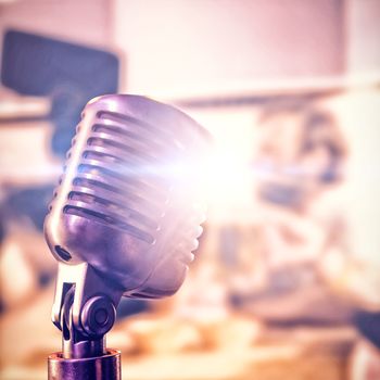 Close-up of microphone  against happy friends toasting beer at nightclub