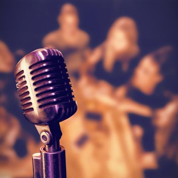 Close-up of microphone  against happy friends toasting at table