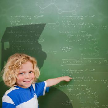 Composite image of cute pupil with graduate shadow in classroom