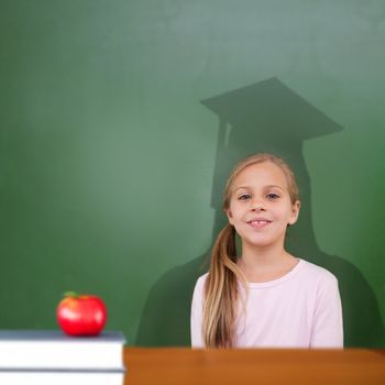 Composite image of cute pupil with graduate shadow in classroom
