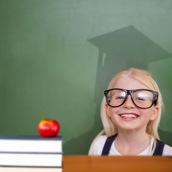 Composite image of cute pupil with graduate shadow in classroom