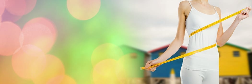 Digital composite of Woman measuring weight with measuring tape on waist near Summer beach huts with transition