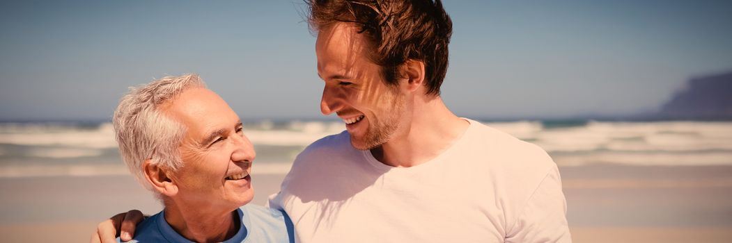 Happy family standing at beach during sunny day