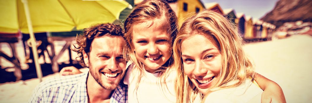 Portrait of smiling family at beach during sunny day