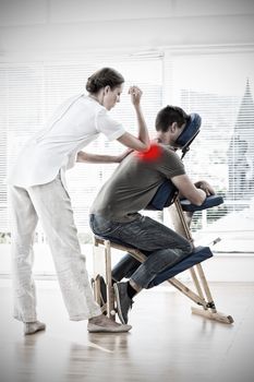 Female therapist giving back massage to man against highlighted pain