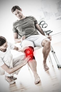 Physiotherapist checking man with crutches  against highlighted pain