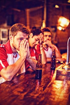 Group of male friends watching football match in pub