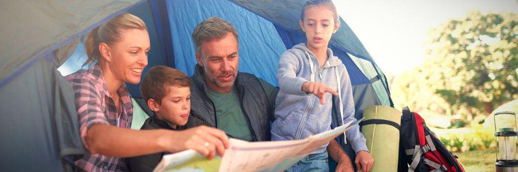 Family reading the map in tent at campsite