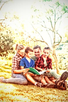 Family reading a book in the park on a sunny day