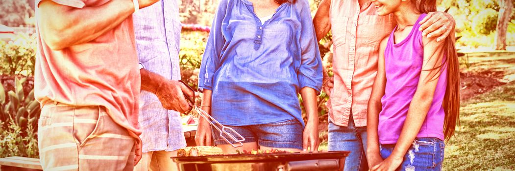 Happy family preparing barbecue in the park