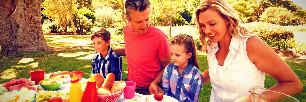 Happy family having meal in park on a sunny day