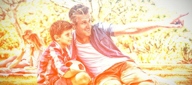 Happy father and son looking at the distance in park on a sunny day