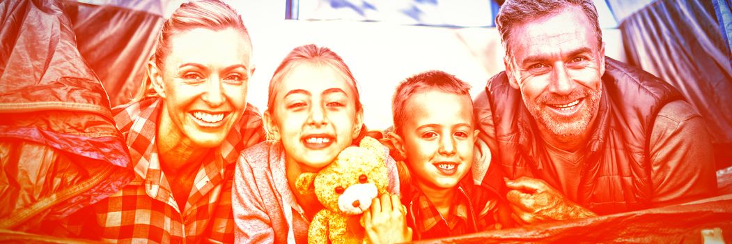 Portrait of smiling family lying in the tent