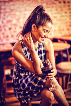 Young woman having red wine in pub