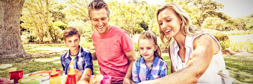 Happy family having meal in park on a sunny day