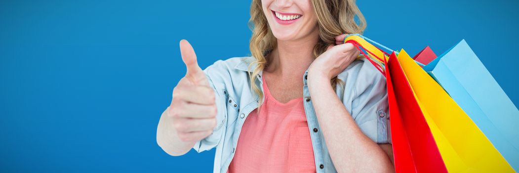 Woman holding some shopping bags against abstract blue background