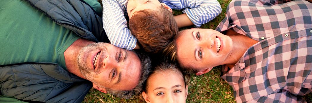 Happy family lying on the grass in park