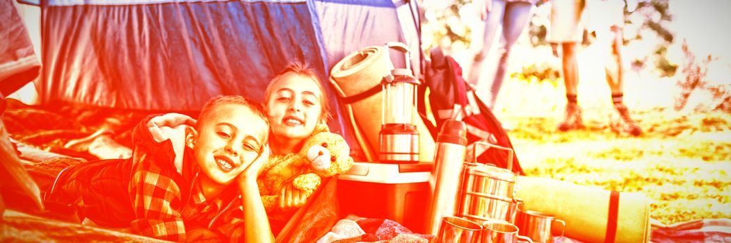 Portrait of siblings lying in the tent