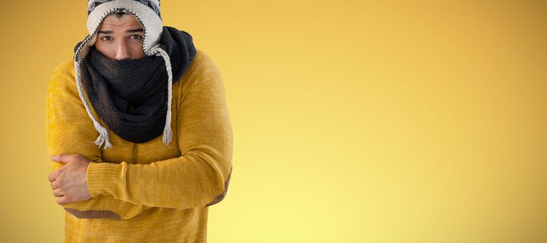 Portrait of man feeling cold against abstract yellow background