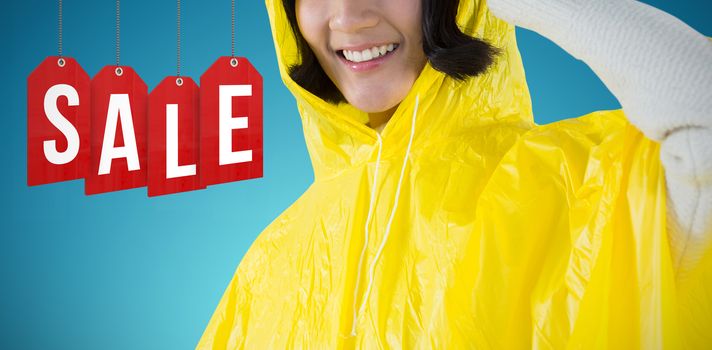 Woman wearing yellow raincoat against white background against abstract blue background