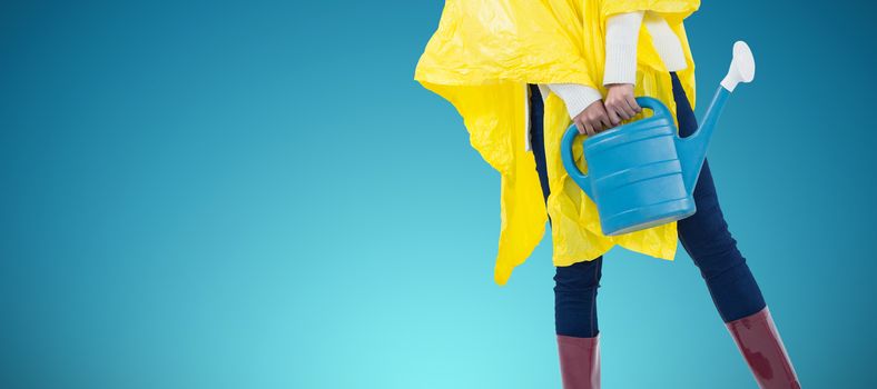 Woman in yellow raincoat holding an watering can against abstract blue background