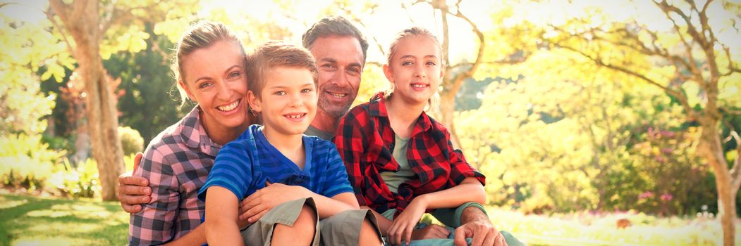 Happy family sitting in the park on a sunny day