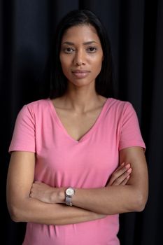women in pink crossing their arms for breast cancer on a black background